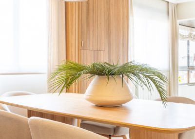 comedor en roble con sillones claros y palilleria lampara de lino maria del valle interiorismo