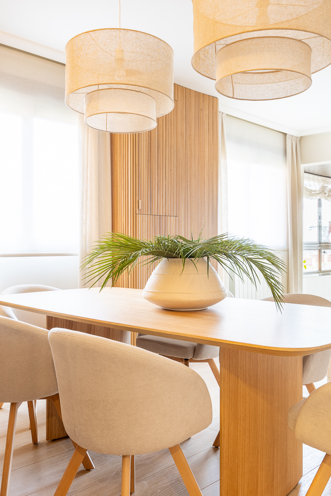 comedor en roble con sillones claros y palilleria lampara de lino maria del valle interiorismo