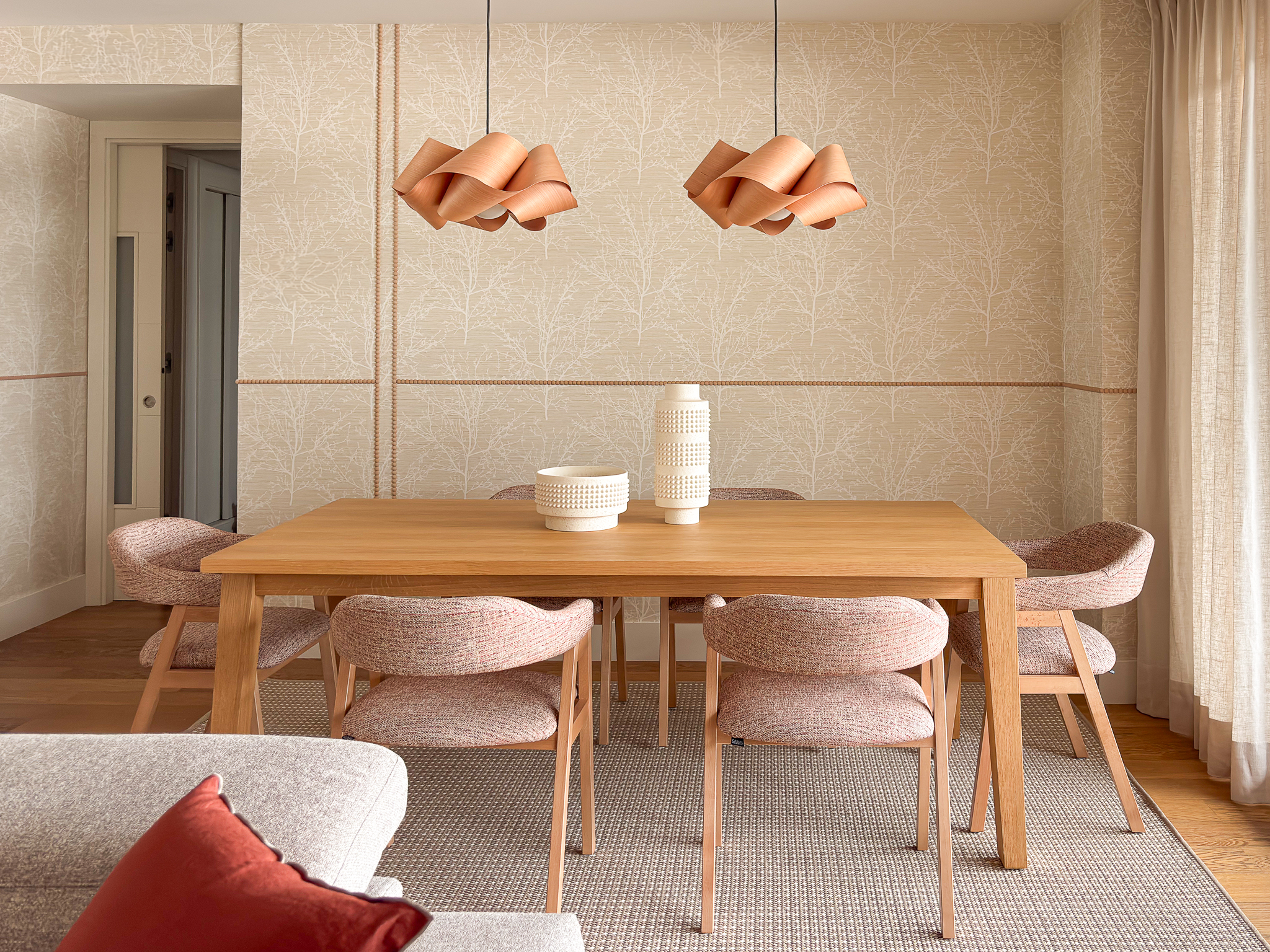 comedor_maria_del_valle_interiorismo_mesa_madera_alfombra_moldura_papel_pintado Comedor con mesa de madera, alfombra neutra y pared con papel pintado y molduras decorativas.