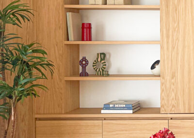 Estantería de madera de roble con objetos decorativos y libros.