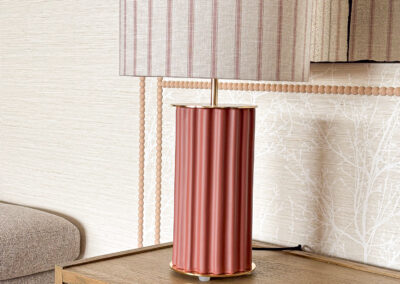 Lámpara de mesa sobre cómoda de madera con papel pintado decorativo en comedor diseñado por María del Valle Interiorismo.