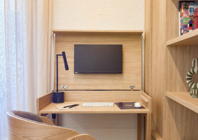 Escritorio a medida de madera de roble con silla ergonómica y ordenador.