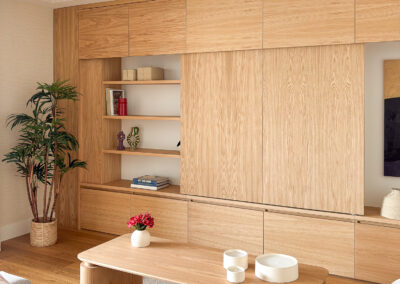 Mueble de salón en madera de roble con estanterías abiertas y mesa de centro en madera.