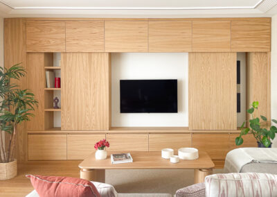 Mueble a medida en madera de roble con televisión integrada y puertas correderas.